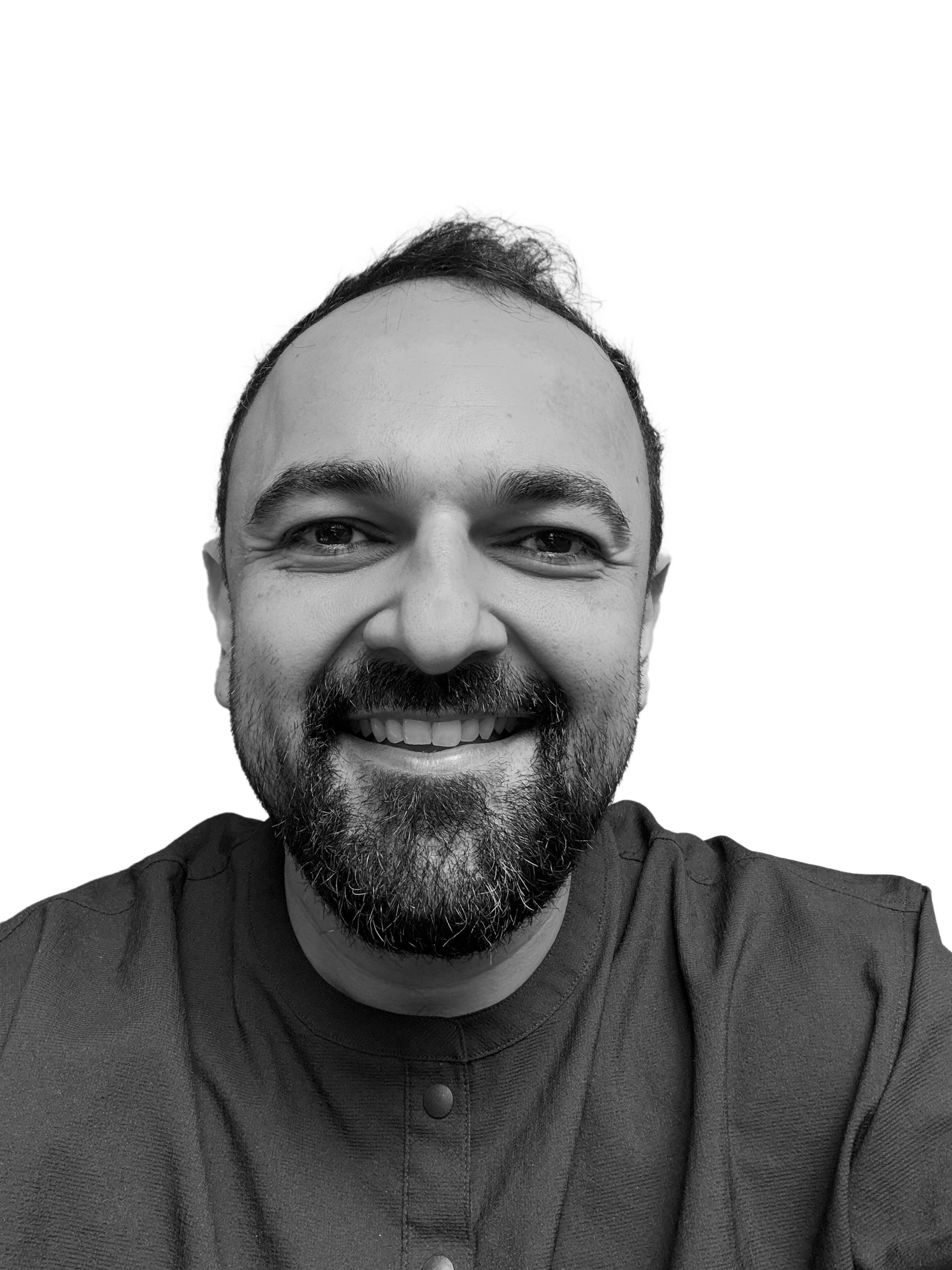 Portrait of a man with brown hair and glasses on a flat gray background.